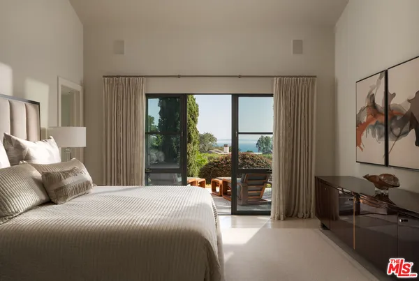 a spacious bedroom with a large bed and a large window