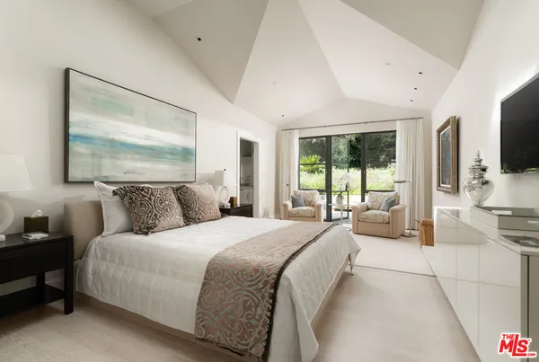 a bedroom with a bed and a chandelier