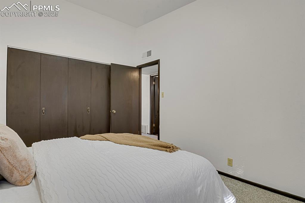 1006 Fontmore Road, Unit C Colorado Springs, CO 80904 - Photo 14 of 33 a bedroom with a bed and a mirror