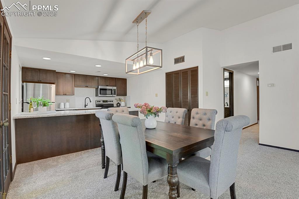 1006 Fontmore Road, Unit C Colorado Springs, CO 80904 - Photo 8 of 33 a view of a dining room and livingroom with furniture wooden floor a rug a painting and a chandelier