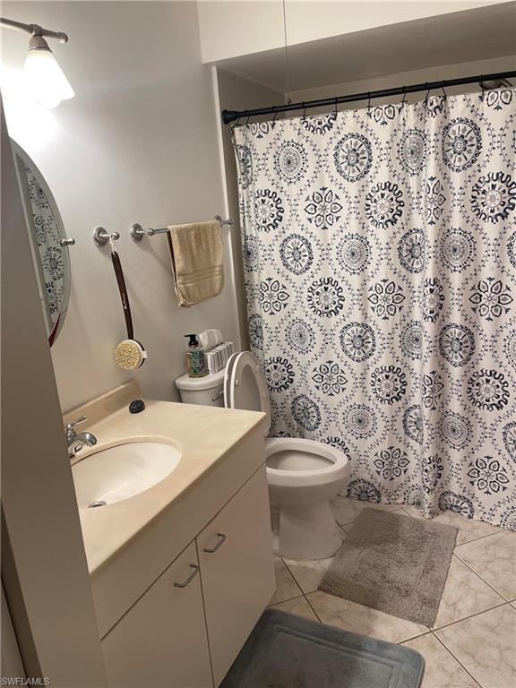 1095 Pine Isle Lane, Unit 1095 Naples, FL 34112 - Photo 6 of 10 a bathroom with a toilet sink and mirror