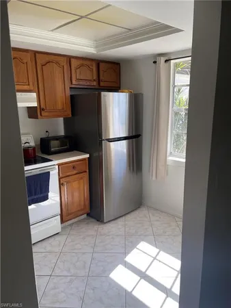 a kitchen with a refrigerator sink and cabinets