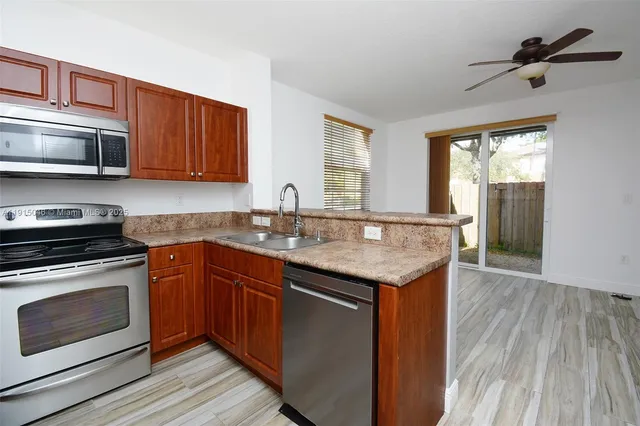 a kitchen with stainless steel appliances granite countertop a stove a sink and a microwave