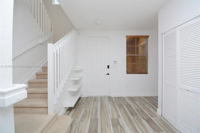 a view of a hallway with wooden floor and staircase