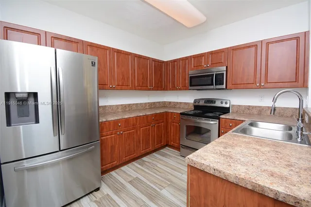 a kitchen with granite countertop a refrigerator stove and microwave