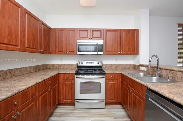 a kitchen with granite countertop wood cabinets and white appliances