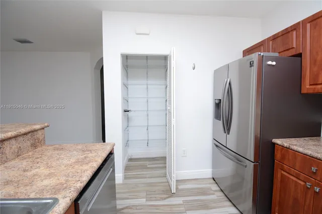 a kitchen with stainless steel appliances granite countertop a refrigerator and a stove