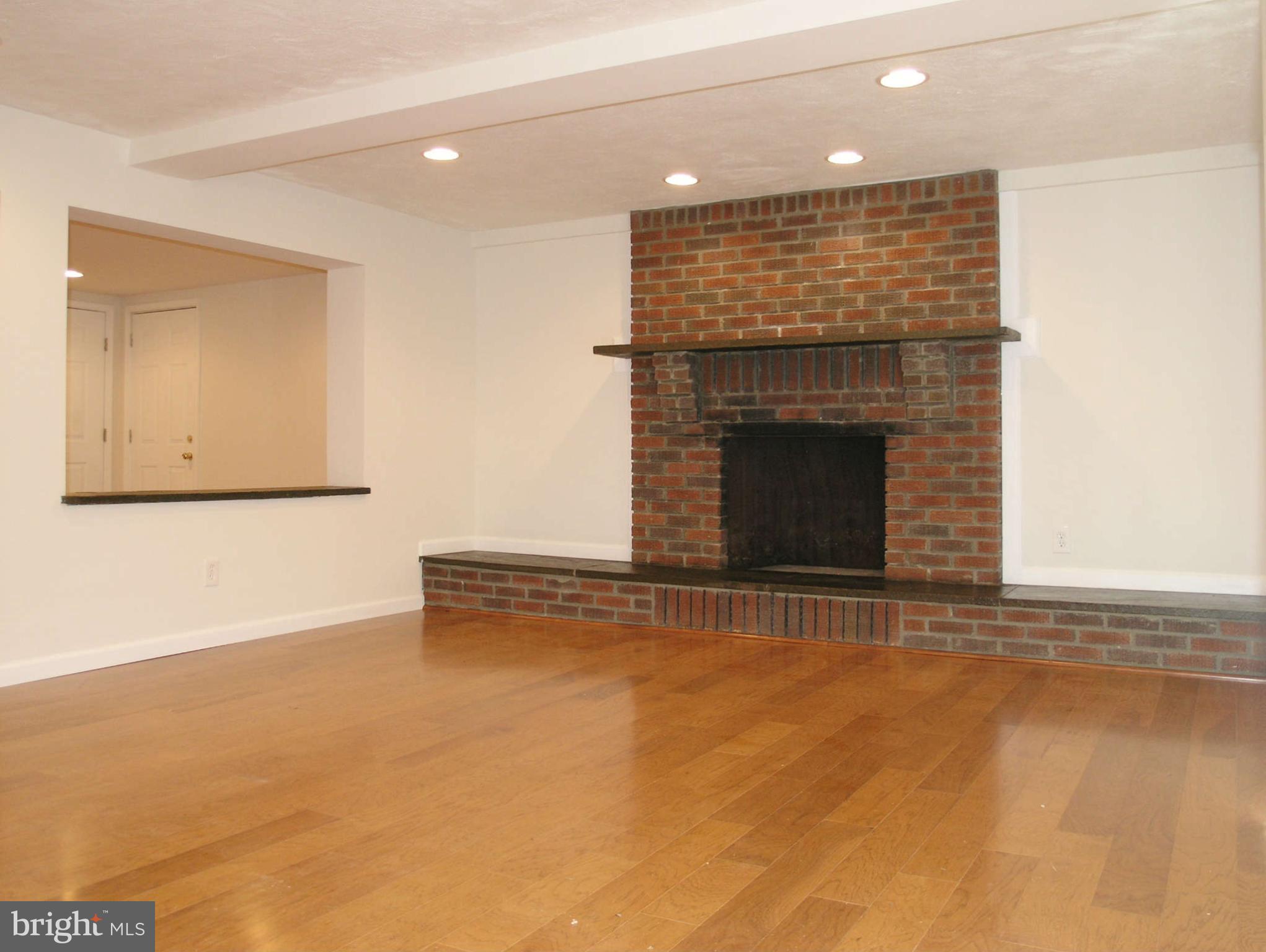 2011 Cascade Road Silver Spring, MD 20902 - Photo 14 of 24 an empty room with wooden floor and fireplace