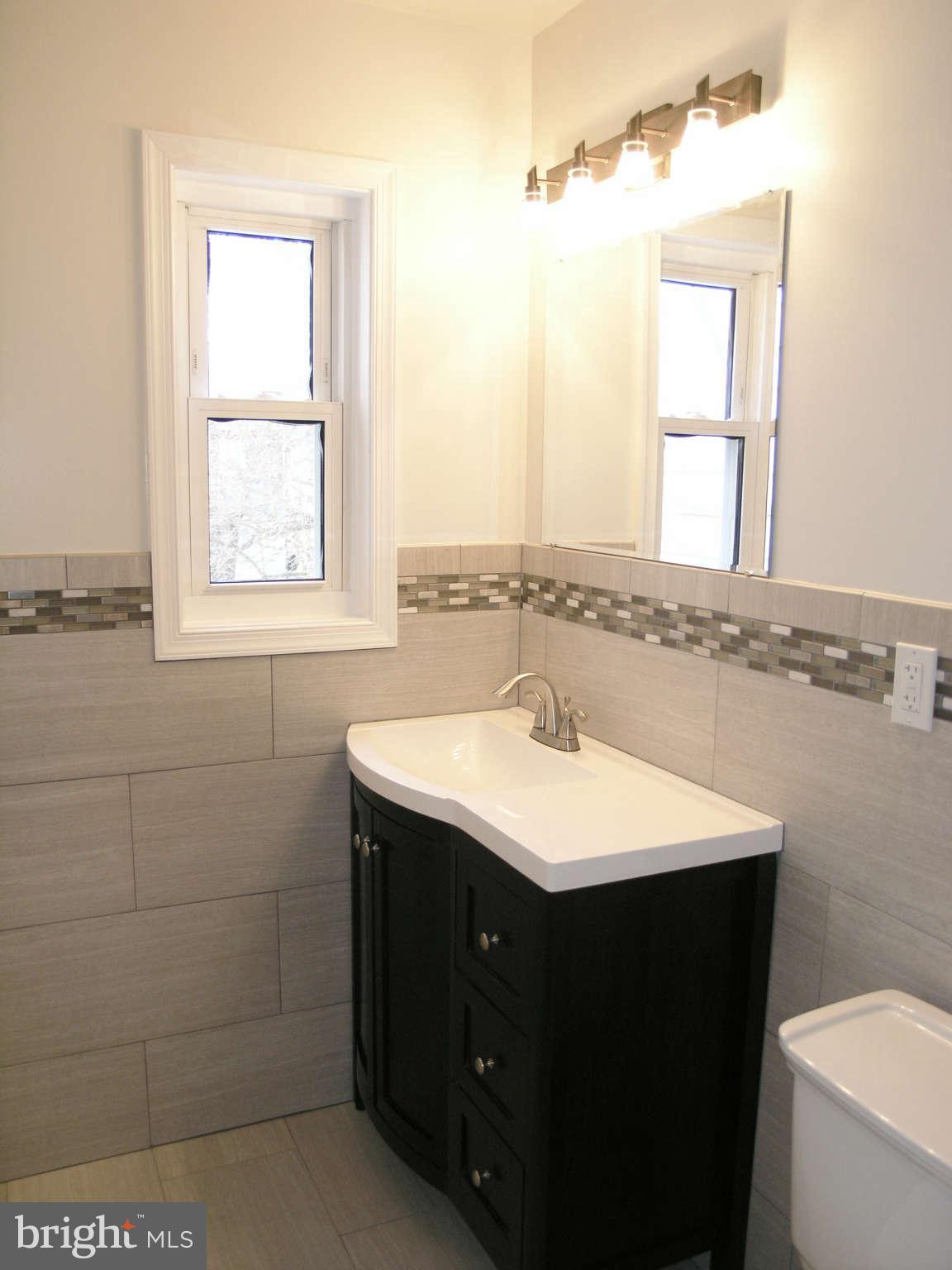 2011 Cascade Road Silver Spring, MD 20902 - Photo 19 of 24 a bathroom with a sink toilet a mirror and window