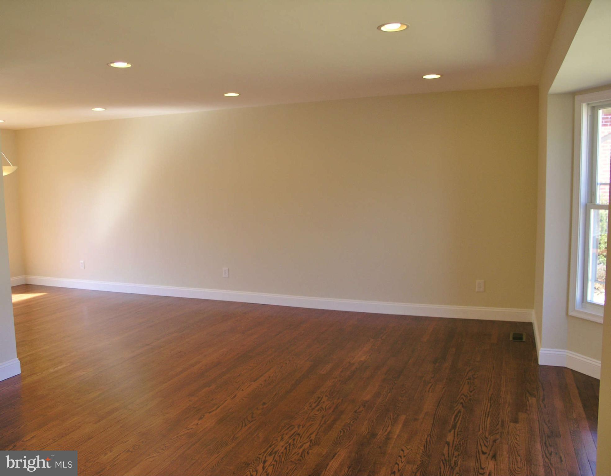 2011 Cascade Road Silver Spring, MD 20902 - Photo 4 of 24 an empty room with wooden floor and windows with curtains