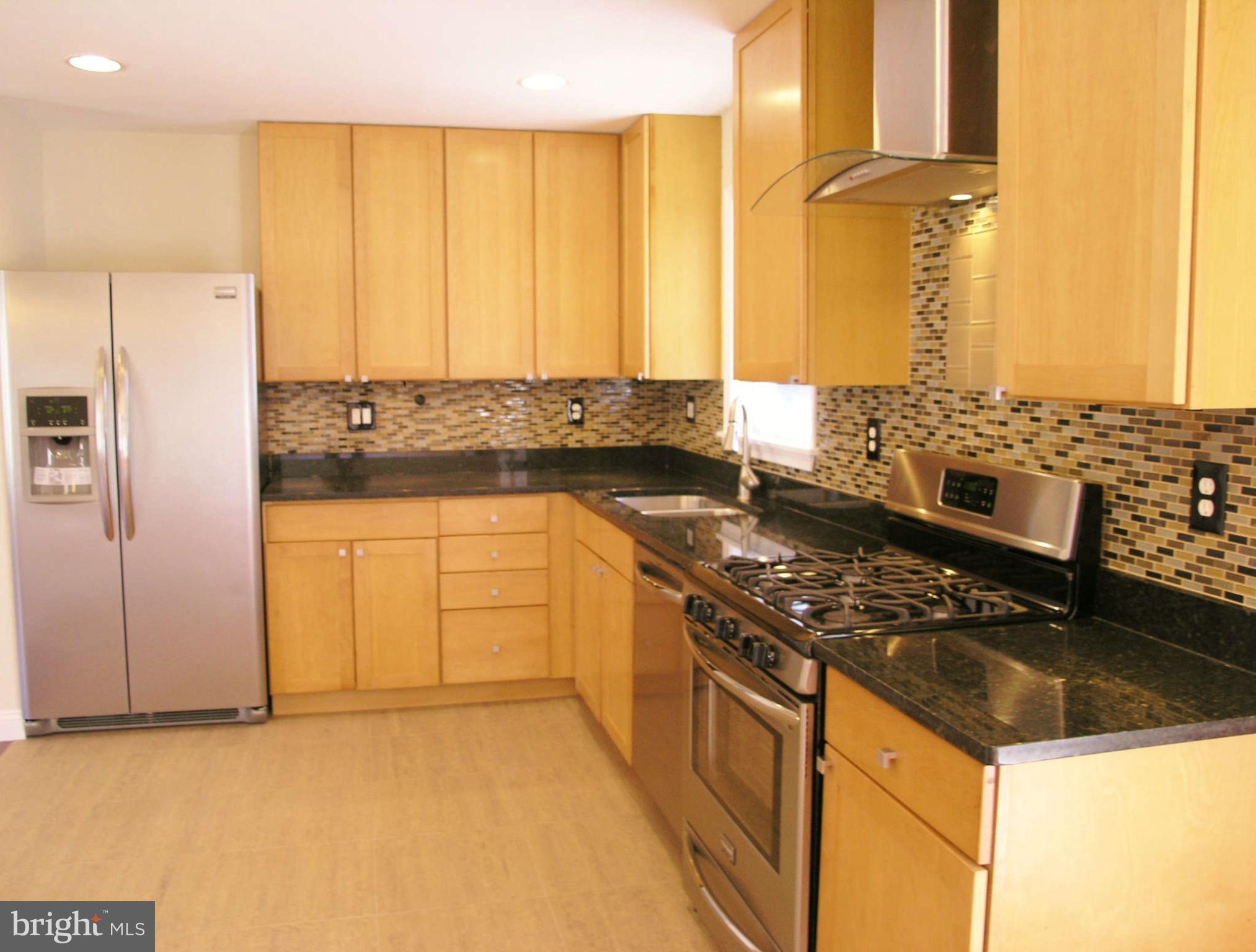 2011 Cascade Road Silver Spring, MD 20902 - Photo 7 of 24 a kitchen with stainless steel appliances granite countertop a stove a sink and a refrigerator