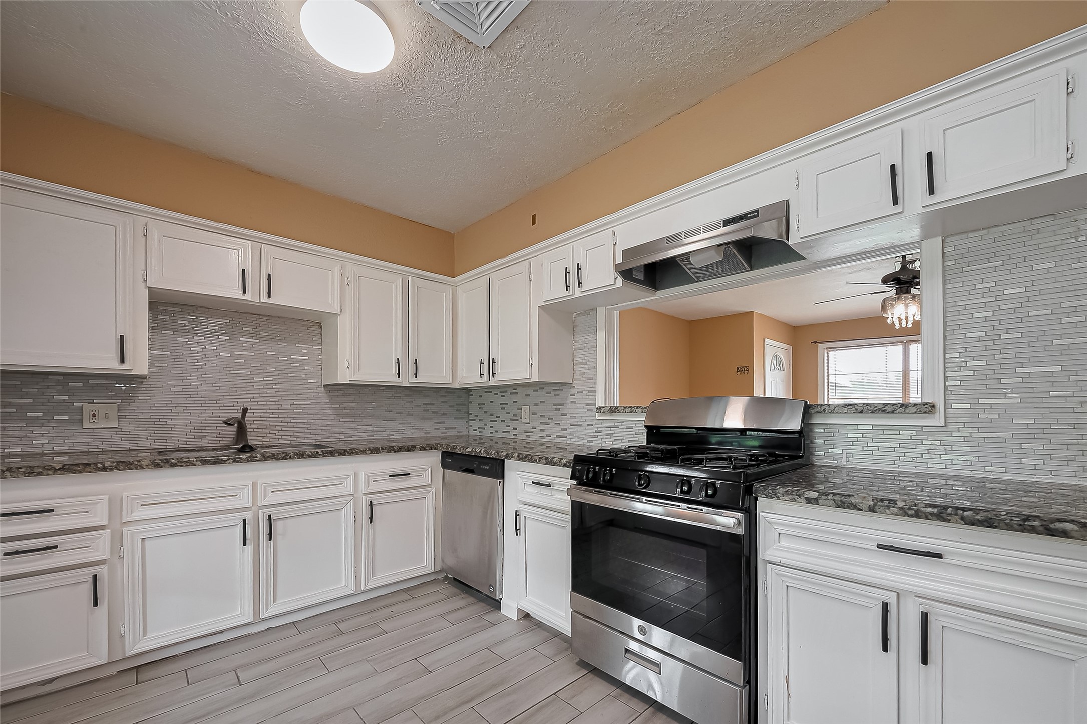 626 Shawnee Street Houston, TX 77034 - Photo 3 of 16 a kitchen with granite countertop a sink a stove and cabinets