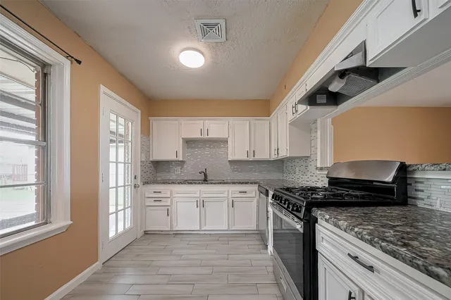 a kitchen with a sink stove and cabinets