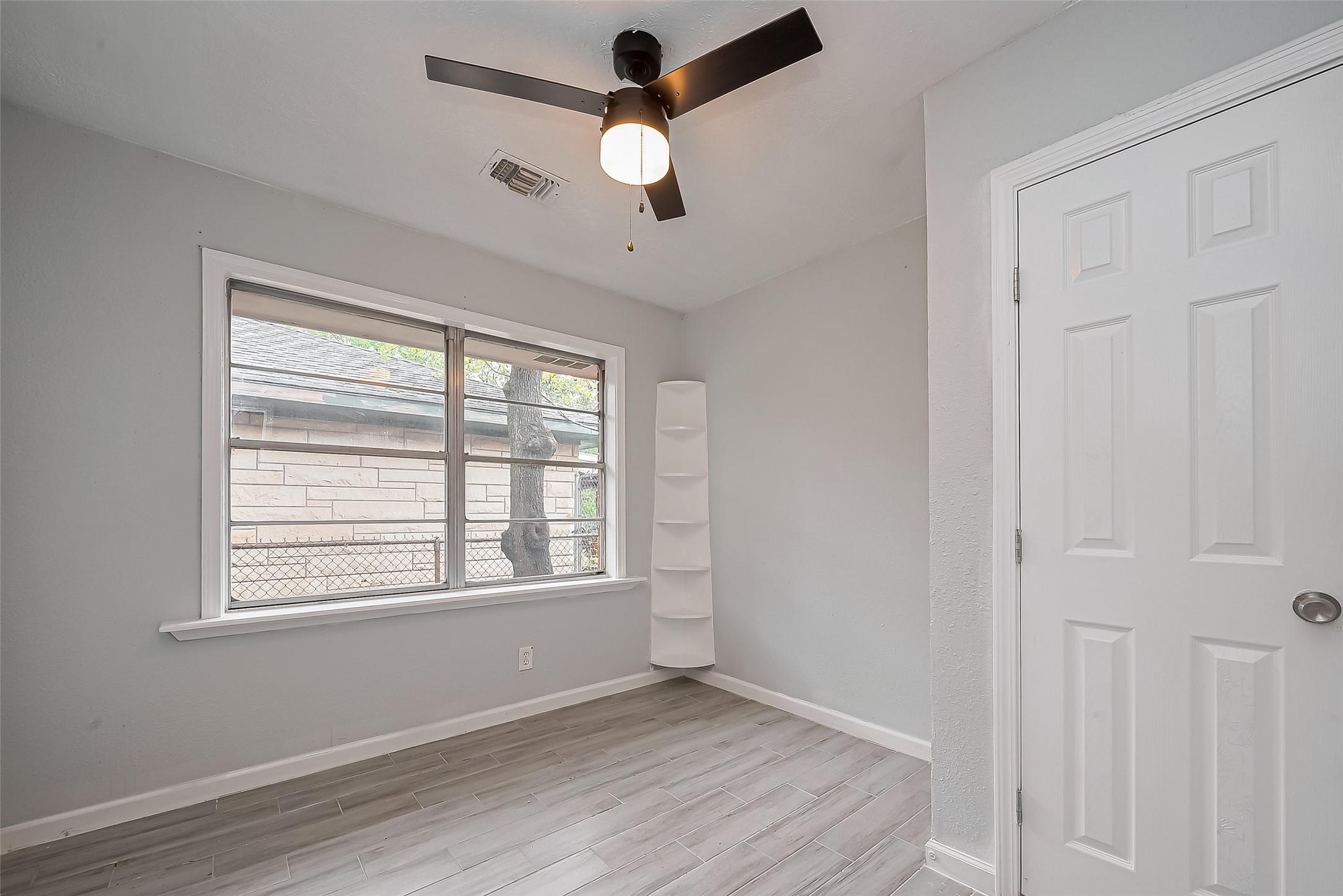 626 Shawnee Street Houston, TX 77034 - Photo 10 of 16 a view of an empty room with a window and wooden floor