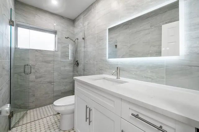 a bathroom with a sink a toilet and shower