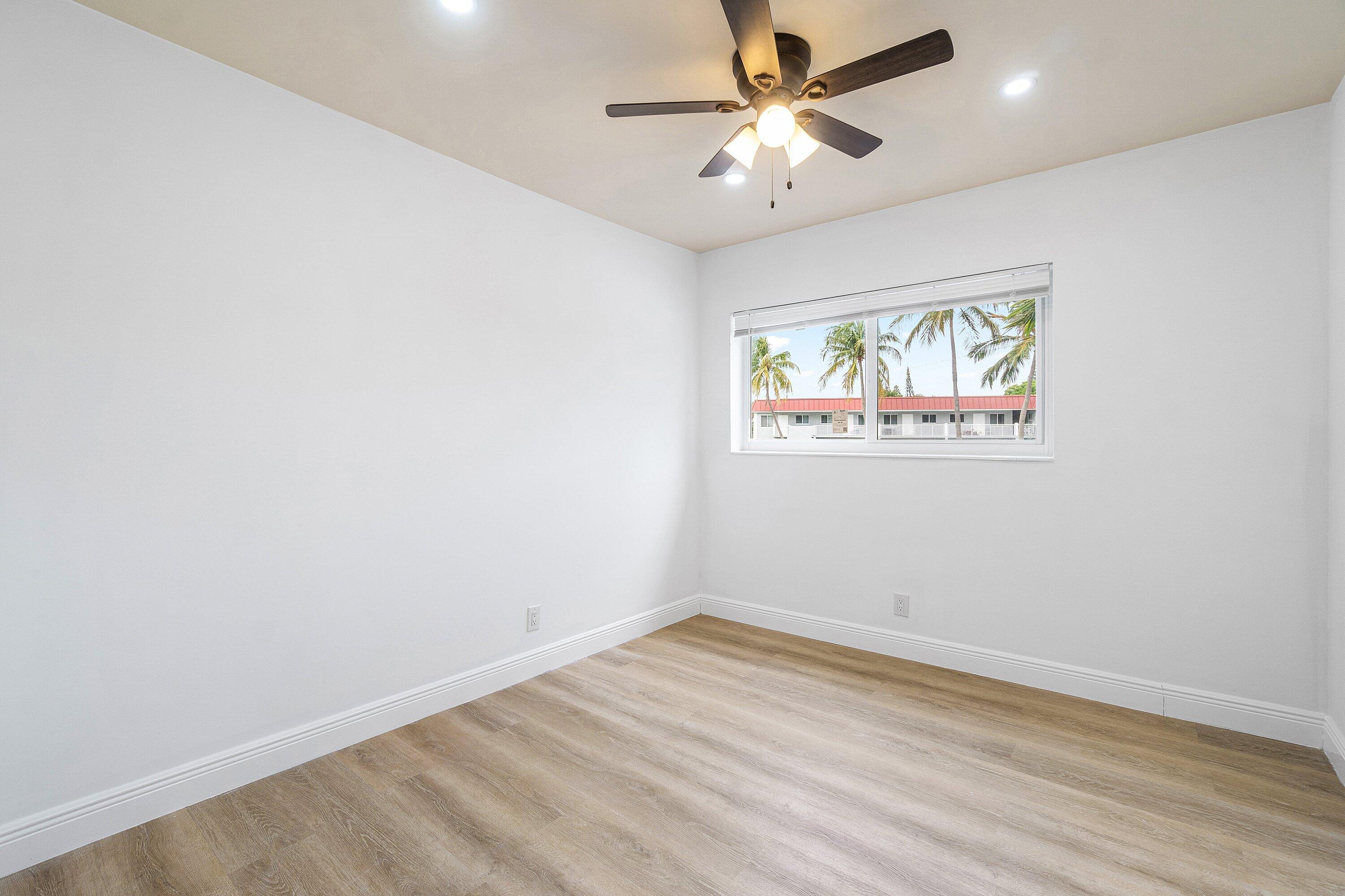 434 Southwest 9th Street, Unit A Boca Raton, FL 33432 - Photo 13 of 22 an empty room with wooden floor and windows
