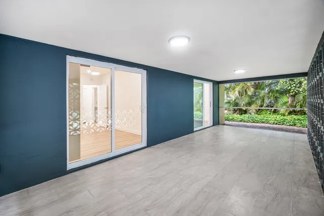 a view of an empty room with wooden floor and doors
