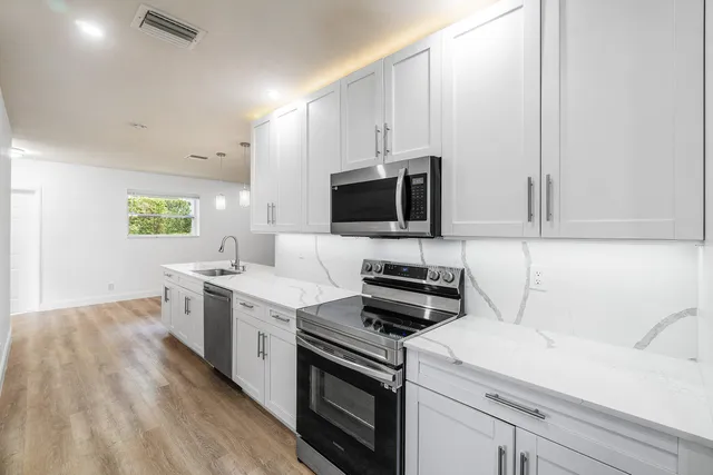 a kitchen with a sink stove and microwave