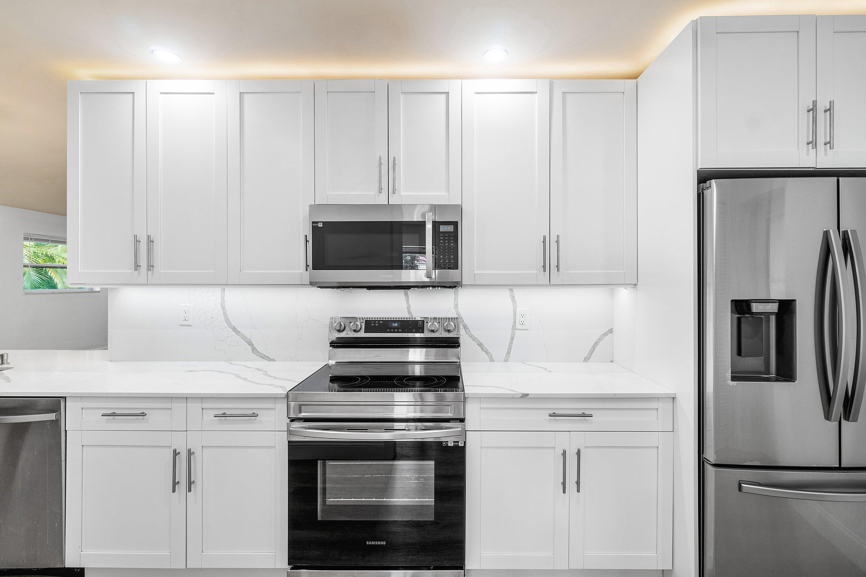 434 Southwest 9th Street, Unit A Boca Raton, FL 33432 - Photo 4 of 22 a kitchen with white cabinets and stainless steel appliances