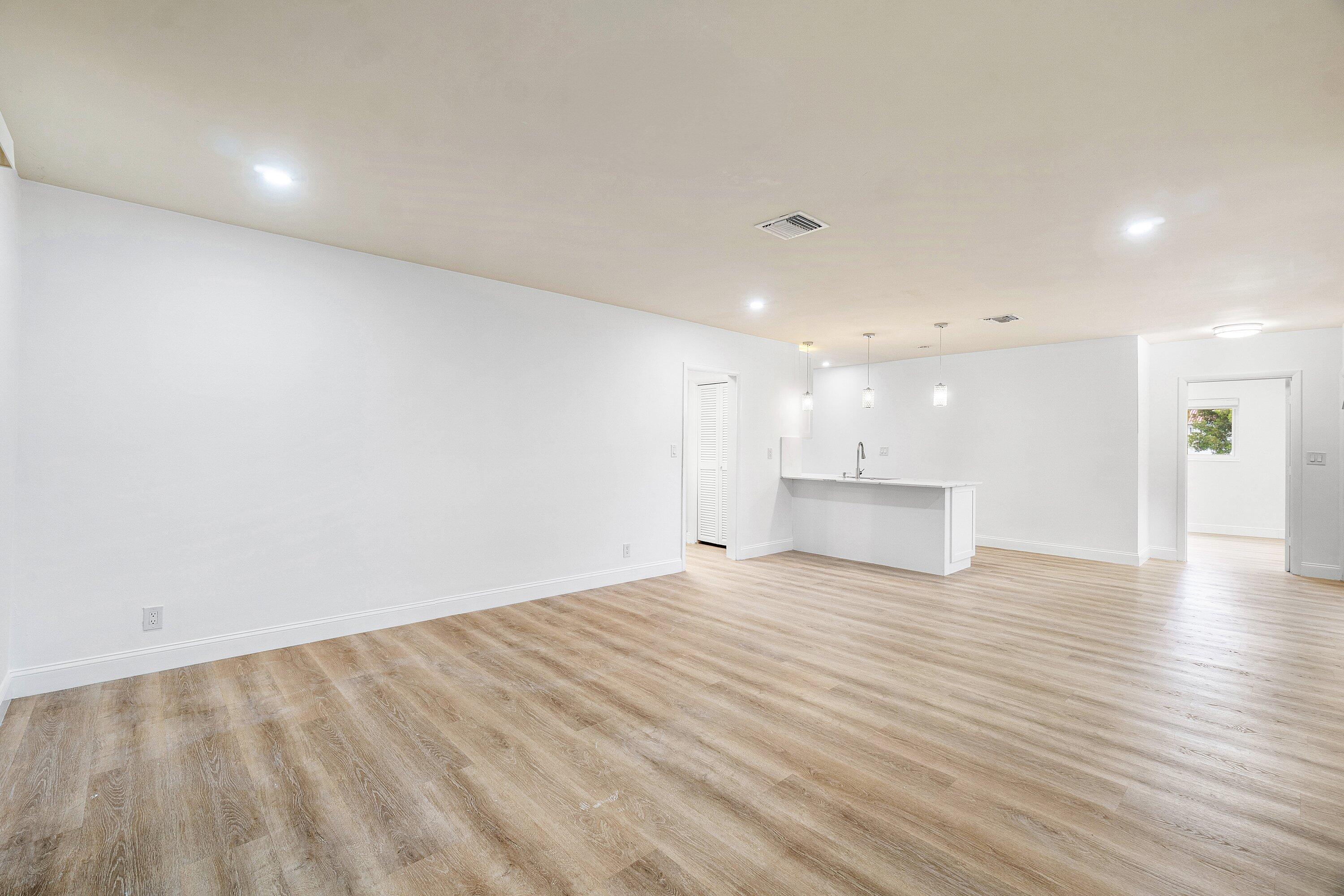 434 Southwest 9th Street, Unit A Boca Raton, FL 33432 - Photo 7 of 22 a view of an empty room with wooden floor and a kitchen