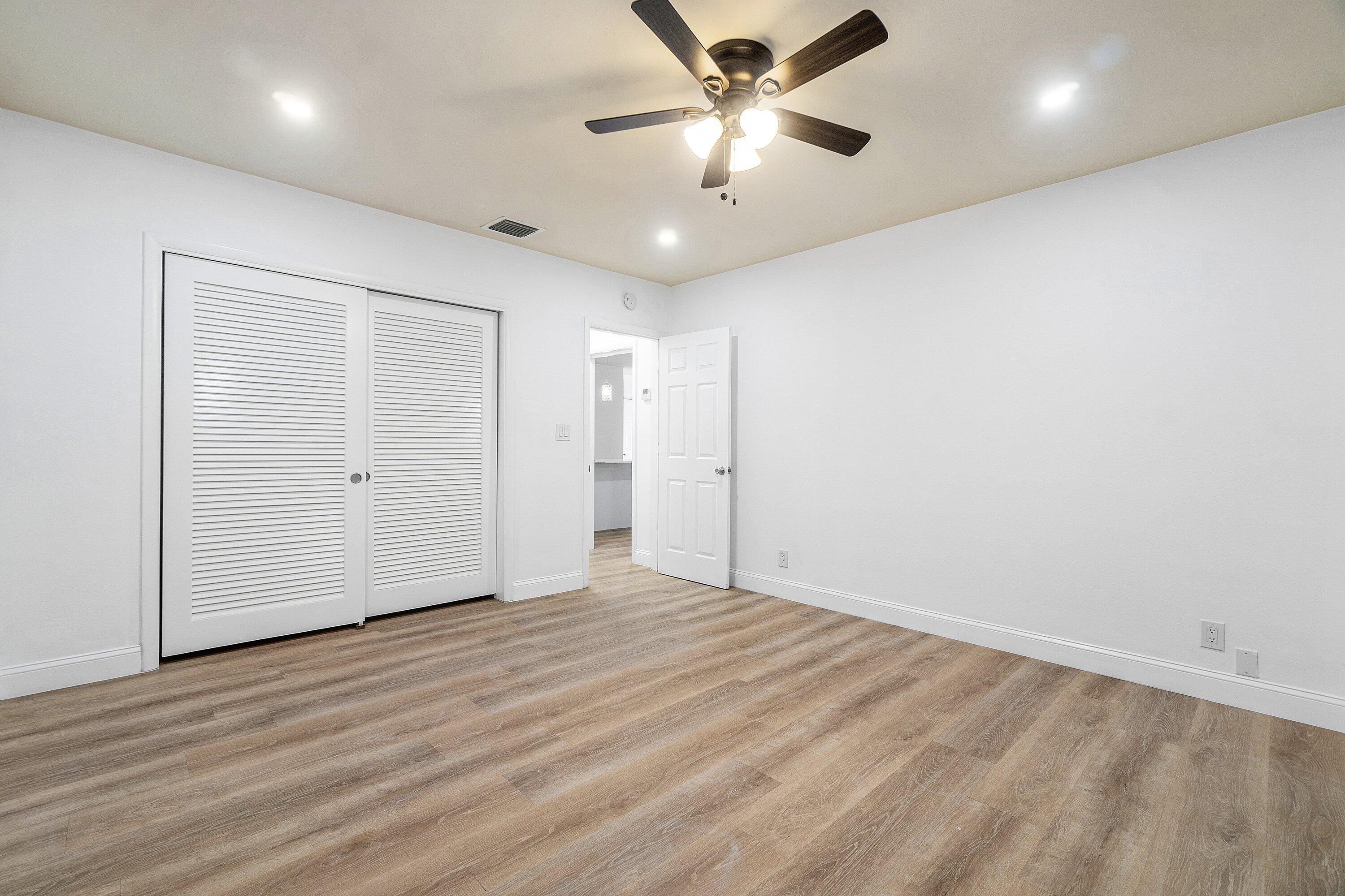 434 Southwest 9th Street, Unit A Boca Raton, FL 33432 - Photo 9 of 22 an empty room with wooden floor and windows