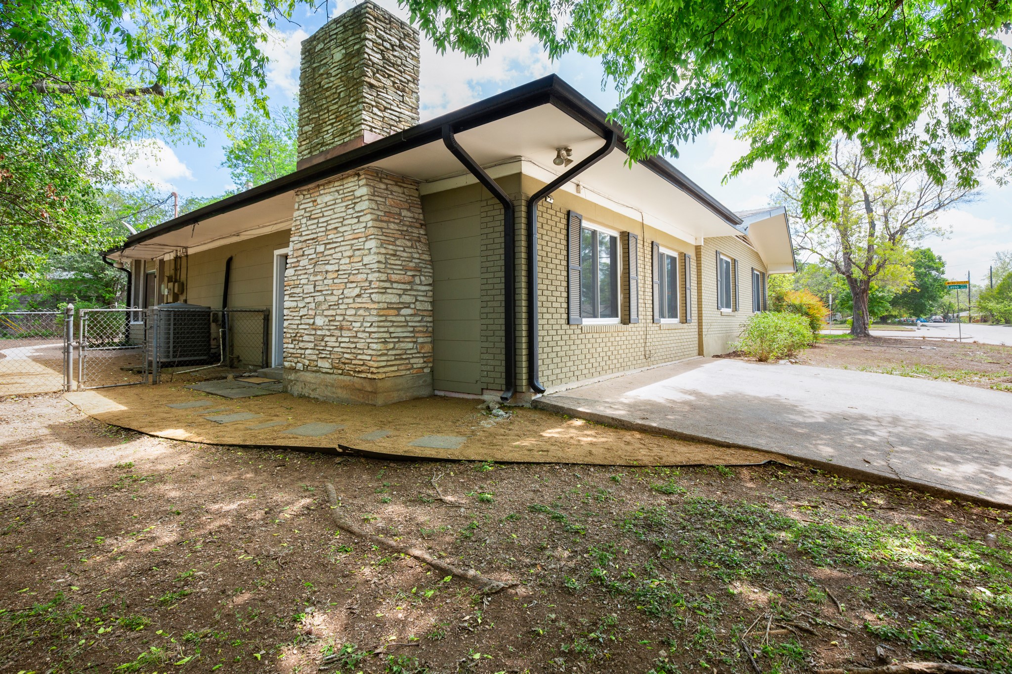 4702 Lasso Path Austin, TX 78745 - Photo 15 of 31 View of side of home featuring a gate, a chimney, and brick siding