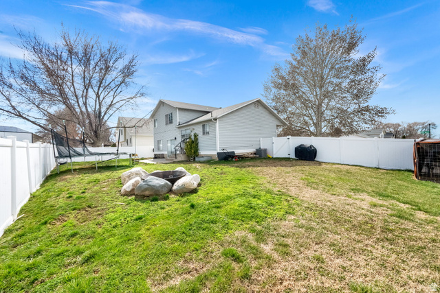 1284 North 900 West Clinton, UT 84015 - Photo 4 of 22 Fenced backyard with a gate and a trampoline