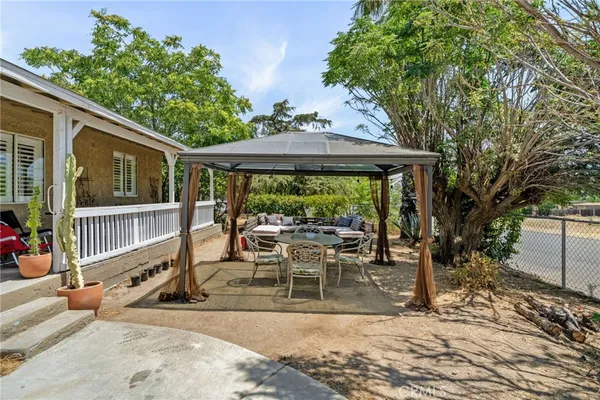 a view of a patio with a table chairs and a floor to ceiling window