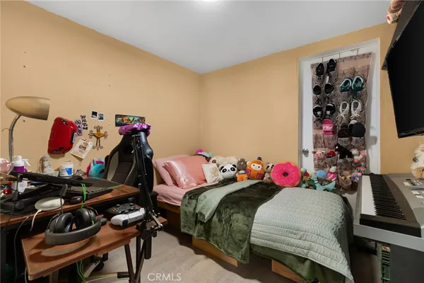 a bedroom with a bed a flat screen tv and dresser