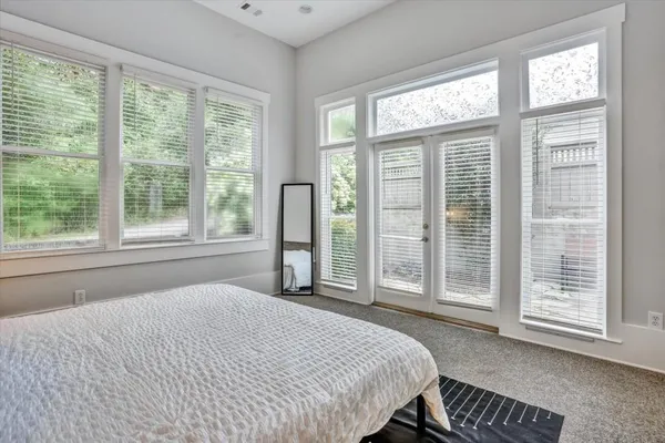 a bedroom with a bed and a large window