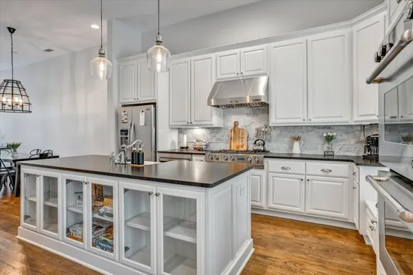a kitchen with stainless steel appliances granite countertop a sink a stove and a refrigerator