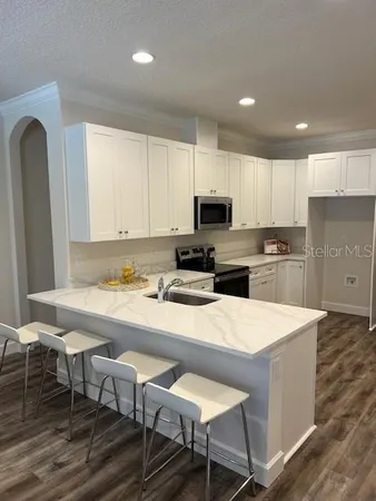 a kitchen with a dining table chairs refrigerator and cabinets