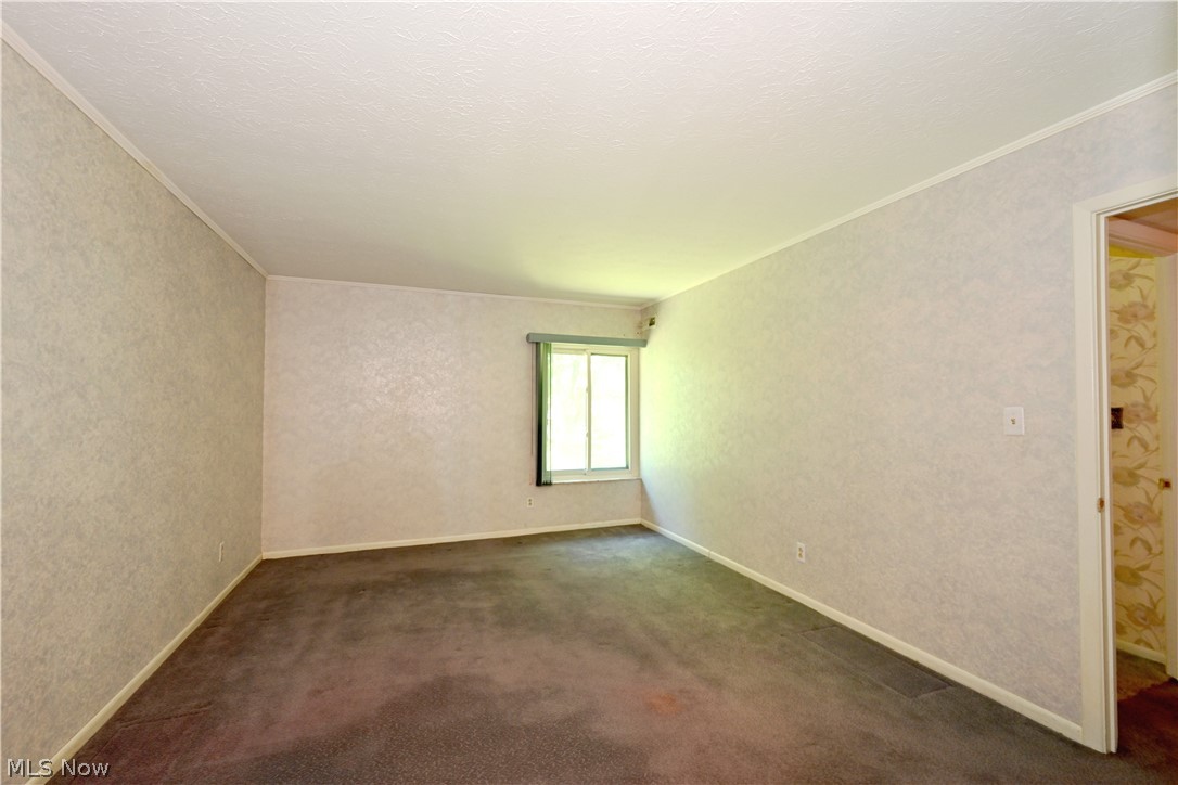 22962 Maple Ridge Road, Unit 206 North Olmsted, OH 44070 - Photo 13 of 33 Carpeted empty room featuring ornamental molding