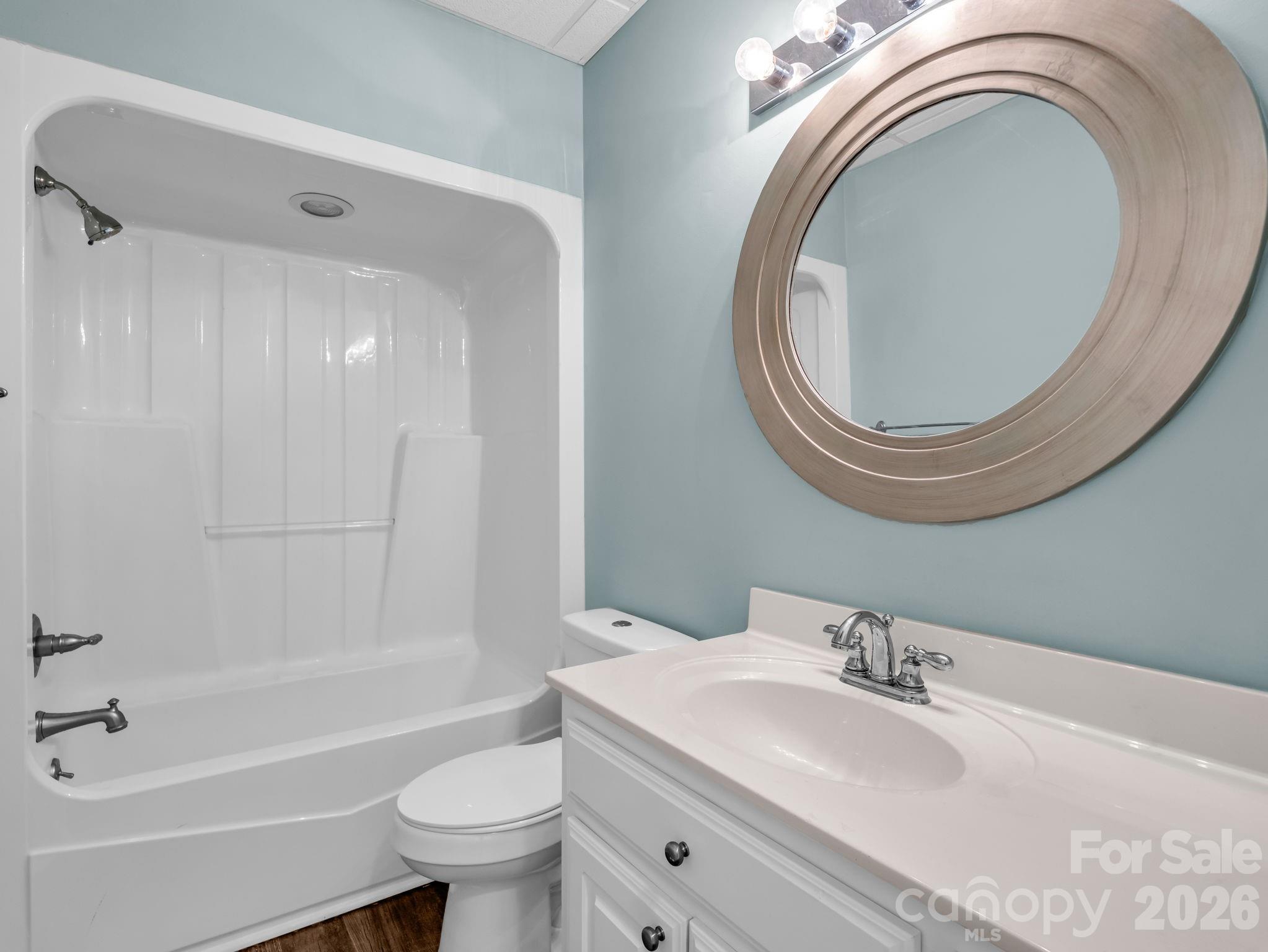 139 North Woodfin Ridge Drive Inman, SC 29349 - Photo 33 of 48 a bathroom with a granite countertop toilet a sink and a mirror