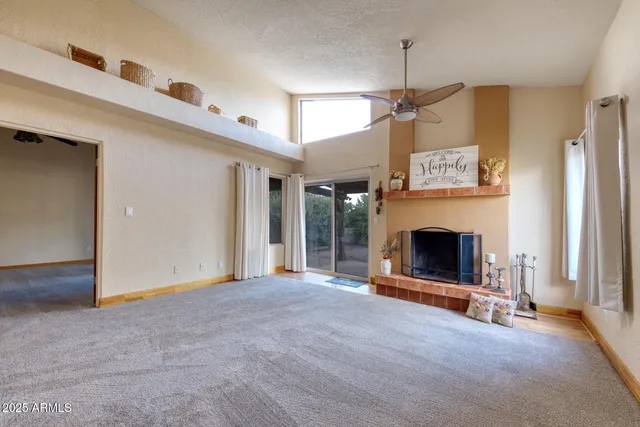 a view of a livingroom with a fireplace and window