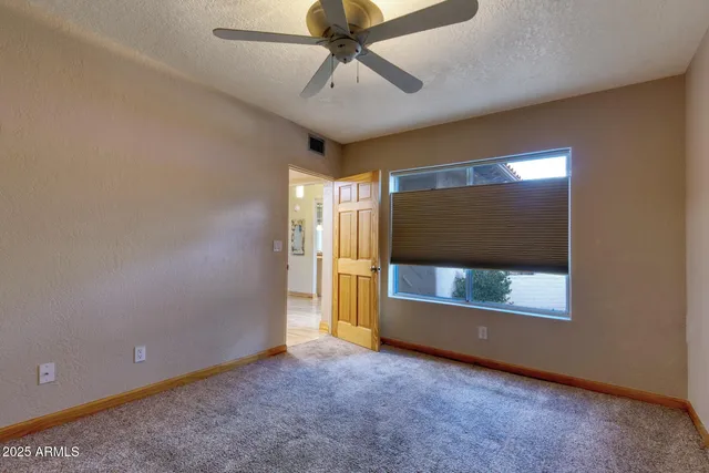 en empty room with window and ceiling fan
