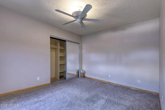 an empty room with closet and fan