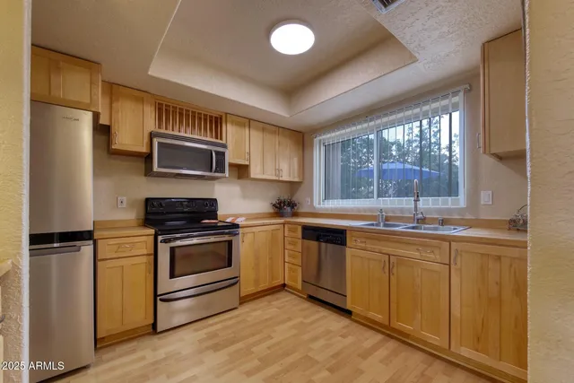 a kitchen with stainless steel appliances granite countertop a stove a sink and a refrigerator