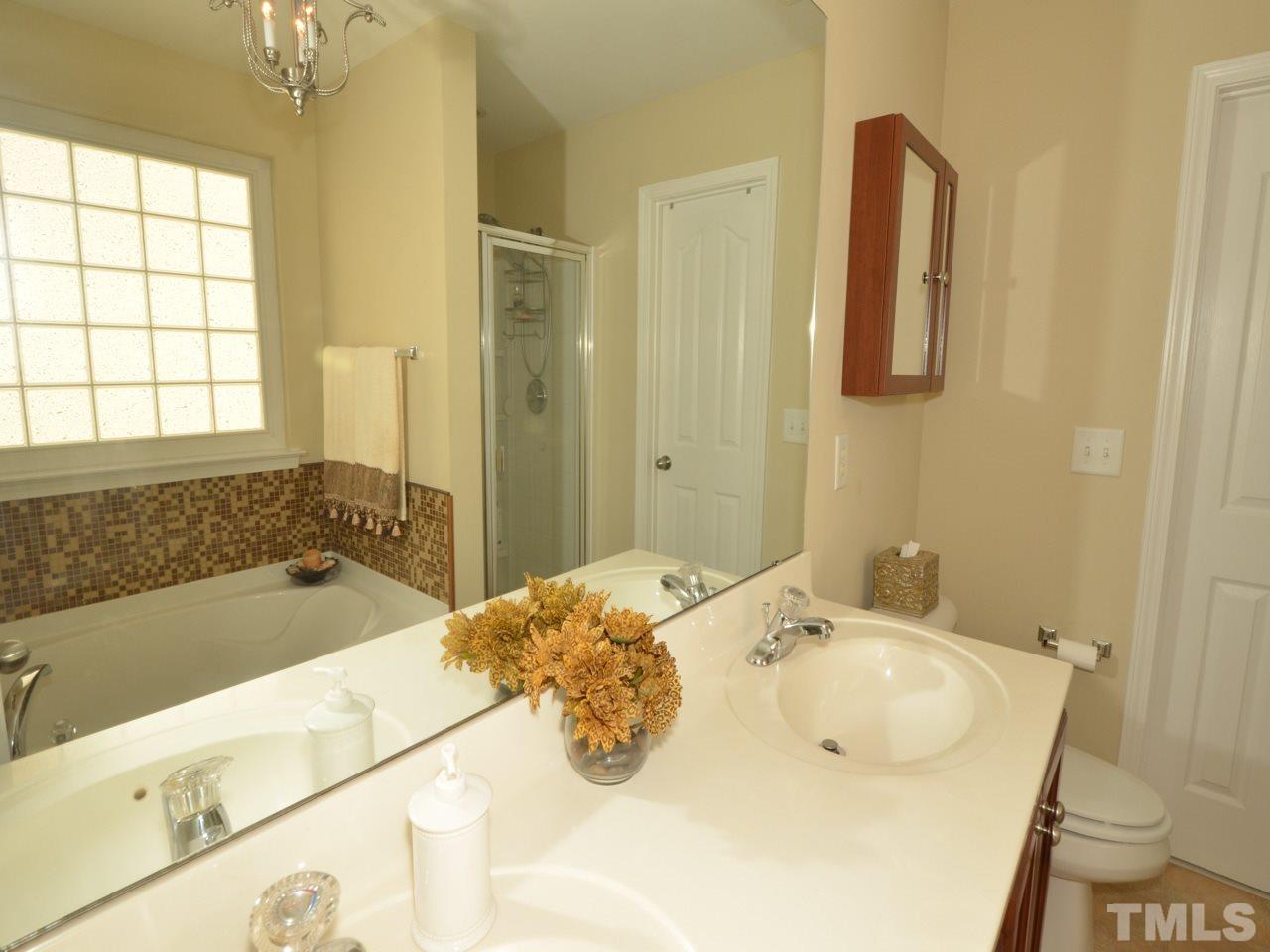 9714 Renfield Drive Raleigh, NC 27617 - Photo 11 of 25 a bathroom with a tub sink and mirror