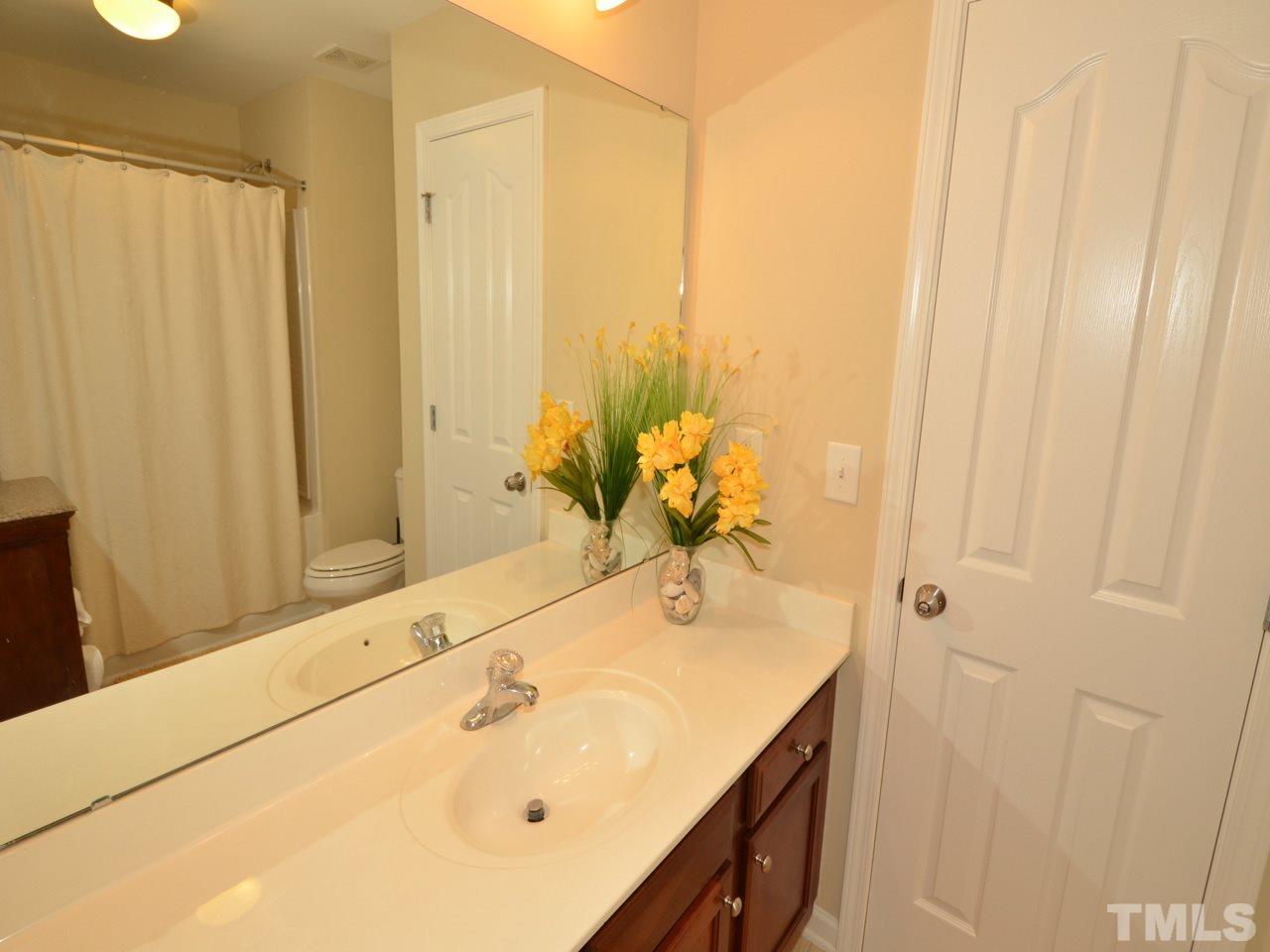 9714 Renfield Drive Raleigh, NC 27617 - Photo 13 of 25 a bathroom with a granite countertop sink and a mirror