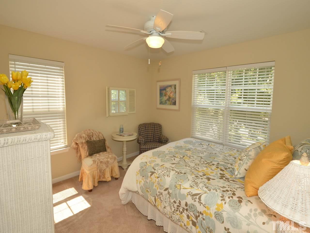 9714 Renfield Drive Raleigh, NC 27617 - Photo 14 of 25 a bedroom with a bed and a chandelier