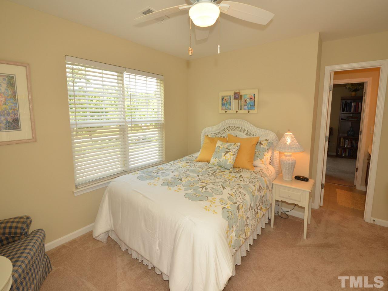 9714 Renfield Drive Raleigh, NC 27617 - Photo 15 of 25 a bedroom with a bed and a chandelier