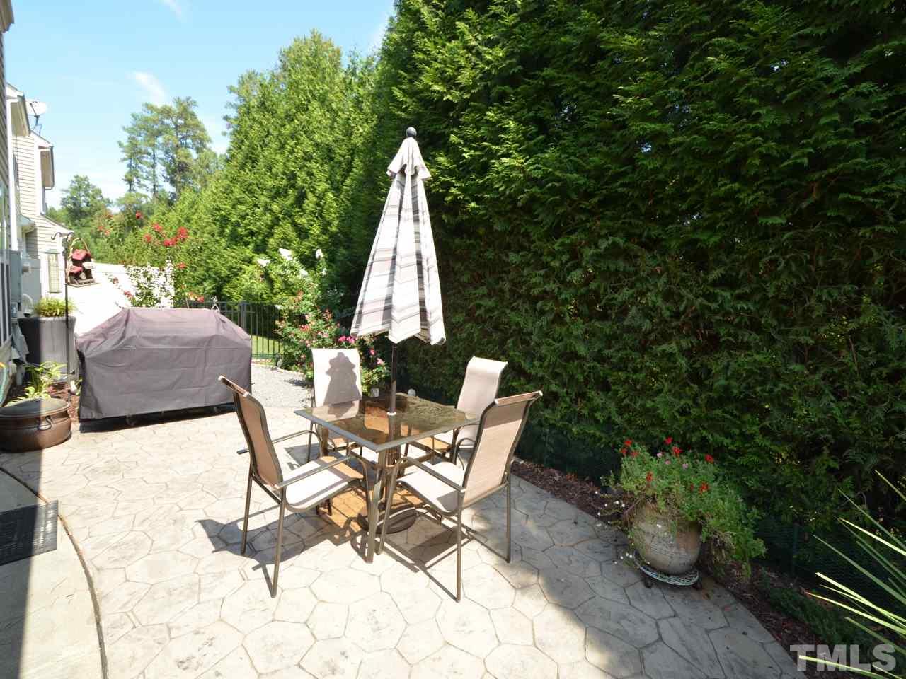 9714 Renfield Drive Raleigh, NC 27617 - Photo 20 of 25 a view of a patio with table and chairs potted plants with wooden fence