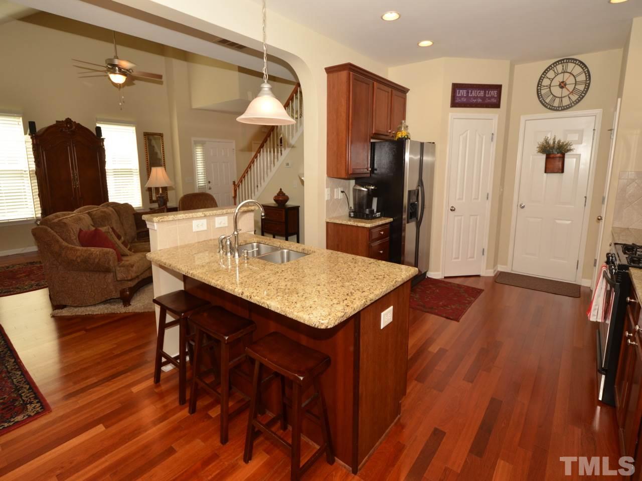 9714 Renfield Drive Raleigh, NC 27617 - Photo 6 of 25 a living room with stainless steel appliances furniture a rug and a kitchen view