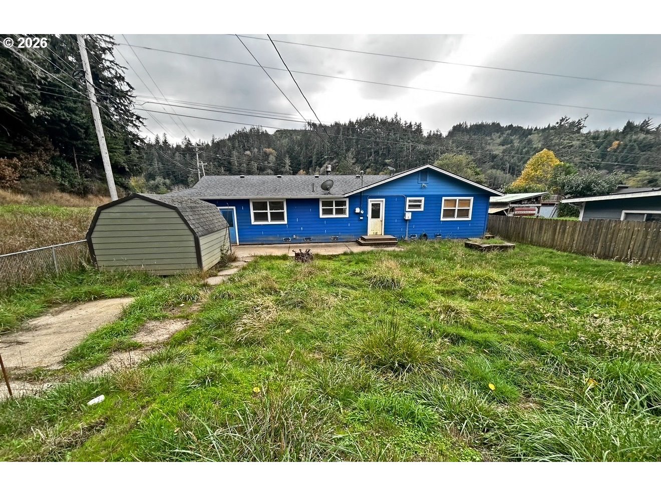 28218 Mateer Road Gold Beach, OR 97444 - Photo 5 of 20 a view of a house with a wooden fence