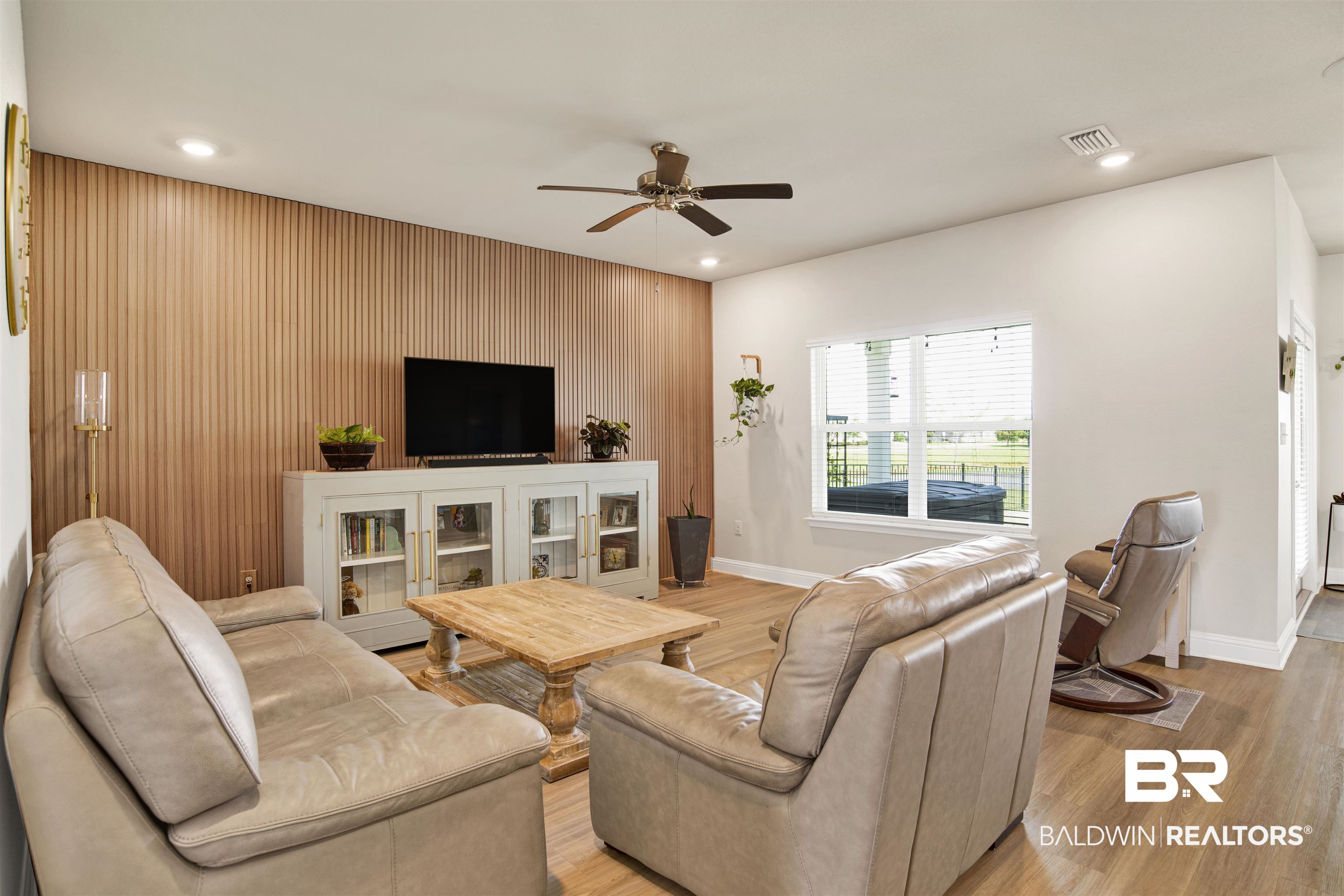 9431 Swan Point Road Daphne, AL 36526 - Photo 12 of 35 Living area featuring an accent wall, ceiling fan, wood finished floors, wood walls, and recessed lighting