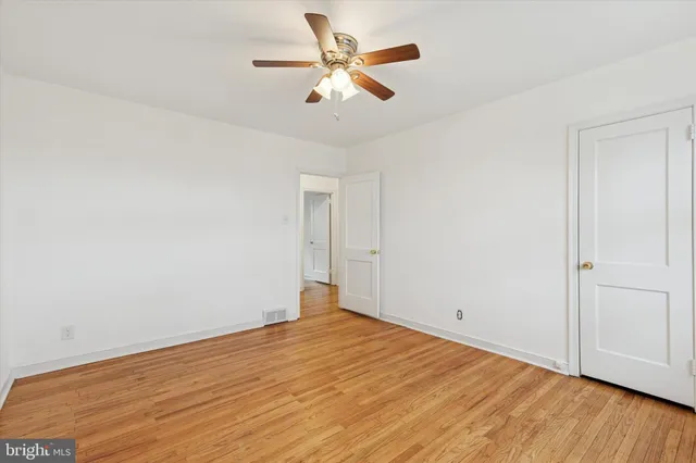 an empty room with a window and a fan