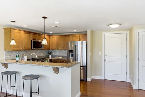 a kitchen with refrigerator cabinets and wooden floor