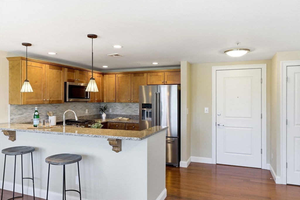 70 Great Road, Unit G Bedford, MA 01730 - Photo 5 of 15 a kitchen with refrigerator cabinets and wooden floor