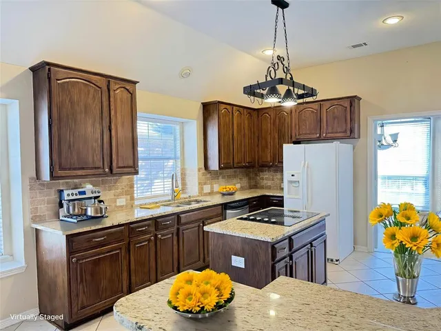 a kitchen with stainless steel appliances granite countertop a sink refrigerator and microwave